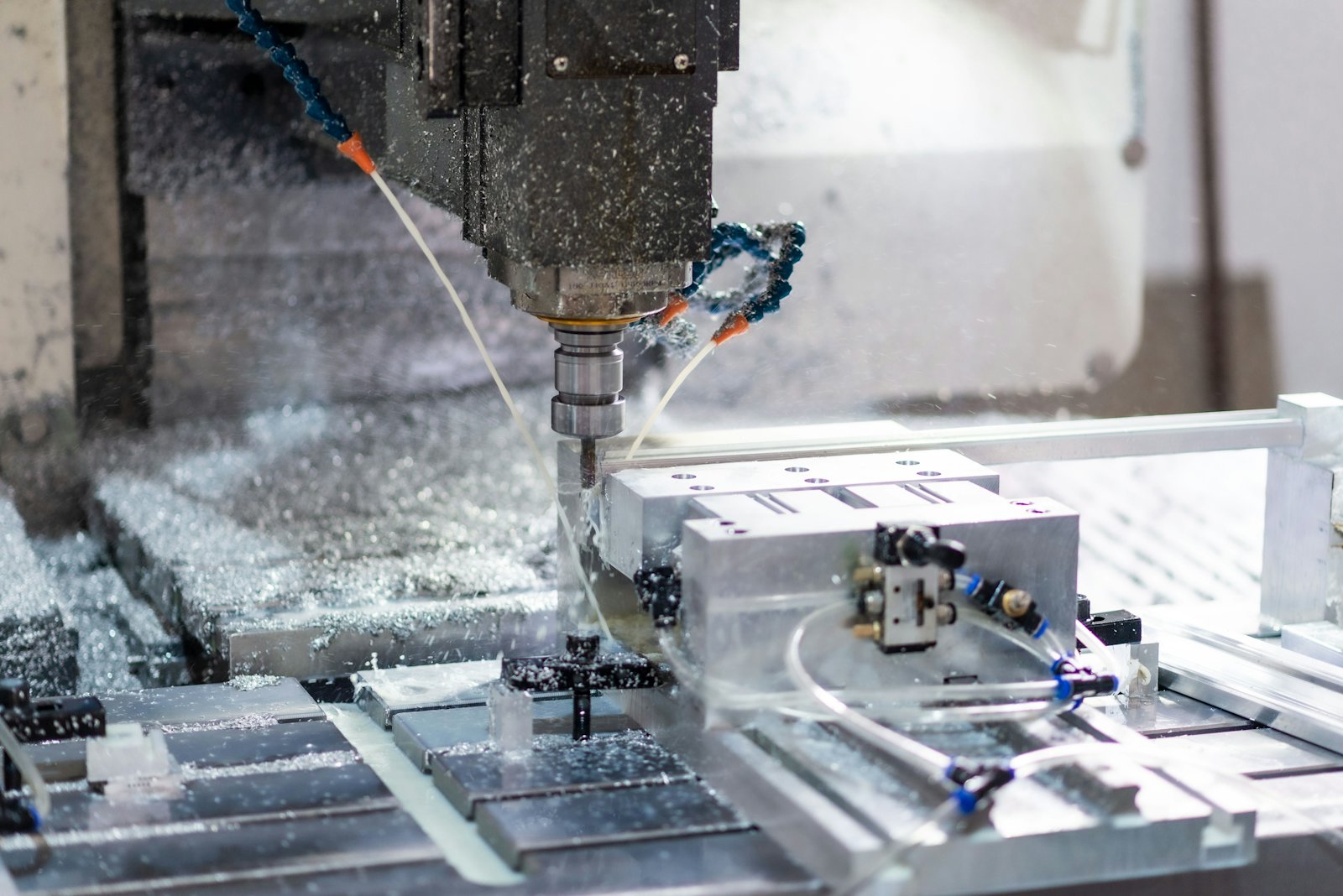 CNC vertical machining center cutting a metal part in a machine shop